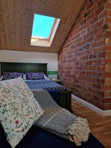 a bedroom with two beds and a brick wall at Pieninė in Ventė