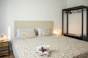 a bedroom with a large bed with towels on it at Preciosa y confortable casa de campo con piscina y chimenea in Carmona +21 photos