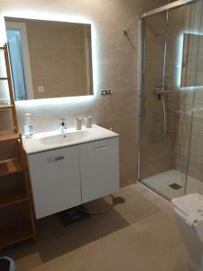 a bathroom with a sink and a shower with a mirror at New build modern ap 4 min walk to the beach and Marbella old town in Marbella