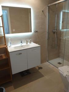 y baño con lavabo y ducha con espejo. en New build modern ap 4 min walk to the beach and Marbella old town, en Marbella