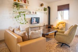 een woonkamer met een bank, 2 stoelen en een tafel bij Preciosa y confortable casa de campo con piscina y chimenea in Carmona