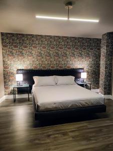 1 dormitorio con 1 cama grande y pared de ladrillo en Casetta Morris, en Valdobbiadene
