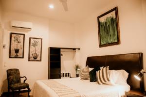sypialnia z dużym łóżkiem i krzesłem w obiekcie Casa Leonardo w mieście Aguascalientes