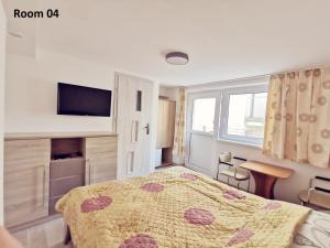 ein Schlafzimmer mit einem Bett und einem TV an der Wand in der Unterkunft Villa Krysia 50 m do morza in Misdroy