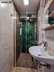 ein Bad mit einem Waschbecken und einer Dusche in der Unterkunft Villa Krysia 50 m do morza in Misdroy