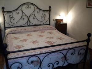 1 dormitorio con 1 cama con colcha de flores en appartamento Ciocci, en San Gimignano
