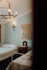 a bedroom with two beds and a chandelier at Forno House in Pereiros