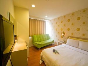 台南的住宿－欣悅商務旅館，酒店客房,设有一张床铺和一张绿色沙发