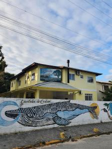 a building with a mural on the side of a wall at Pousada Figueira in Guarda do Embaú