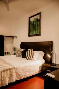 sypialnia z łóżkiem i zdjęciem na ścianie w obiekcie Casa Leonardo w mieście Aguascalientes