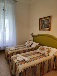two beds sitting in a room with a window at Tucci's Roma Guest House in Rome