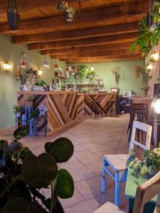 um restaurante com um balcão com cadeiras e mesas em Casale Boschi - Rifugio di Pianura em Cotignola