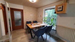 ein Esszimmer mit einem Tisch, Stühlen und einem Fenster in der Unterkunft Ferienhaus Am Vitzerod in Tambach-Dietharz