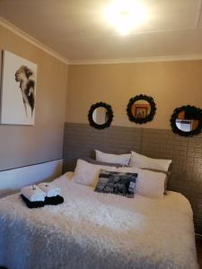 ein Schlafzimmer mit einem großen Bett mit zwei Spiegeln an der Wand in der Unterkunft African Elephant's Den in Klerksdorp