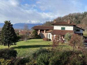 een huis in een veld met bergen op de achtergrond bij MyVilla B&B in Palazzo Canavese