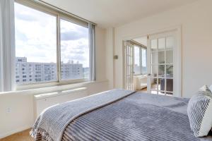 a bedroom with a bed and large windows at Cozy 2 BR Apartment At Arlington With Gym in Arlington