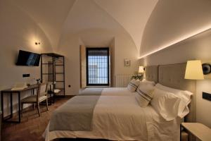 a bedroom with a bed and a desk and a computer at Hotel Casa Ernestina in Zafra