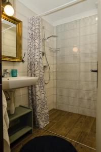 La salle de bains est pourvue d'un rideau de douche et d'un lavabo. dans l'établissement Ubytovanie pod Homôlkou, à Jamník