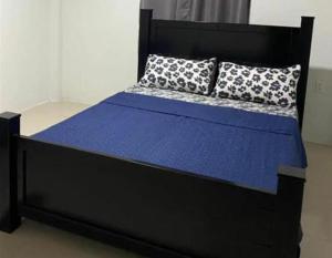 a black bed with blue sheets and pillows on it at Charming 1-Bed House in Georgetown in Georgetown