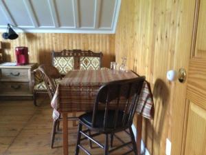 een eetkamer met een tafel en stoelen en een kamer met houten wanden bij Gite chez Gilles Lévesque in Saints-Anges