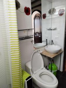 a bathroom with a toilet and a sink at Hotel Quilla House 2 in Urubamba