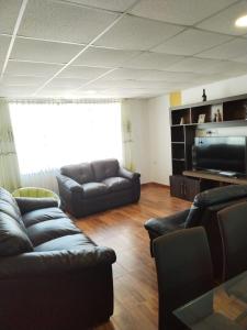 Sala de estar con 2 sofás y TV en Hotel Quilla House 2, en Urubamba