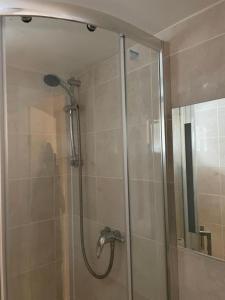 um chuveiro com uma porta de vidro na casa de banho em The Mews em Erith