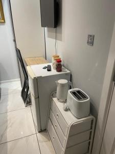 a kitchen with a stove and a tv in a room at The Mews in Erith