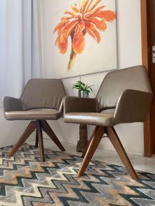 una silla de cuero sobre una alfombra en la sala de estar en Residencial COLIBRI, en Garopaba