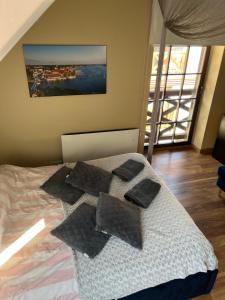 a bedroom with a bed with pillows on it at Apartament Sunrise in Mikołajki