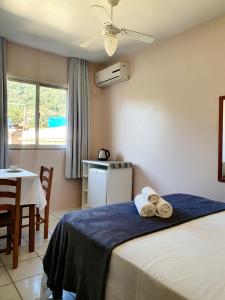 een hotelkamer met een bed met handdoeken erop bij Pousada Figueira in Guarda do Embaú