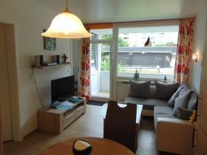 sala de estar con sofá y TV en Ridders Ferienpark 1 319, en Hahnenklee-Bockswiese