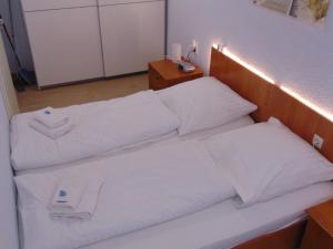 una cama con almohadas blancas en una habitación en Ridders Ferienpark 1 319, en Hahnenklee-Bockswiese