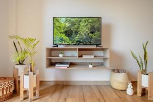 En TV eller et underholdningssystem på Xifra Condos with ocean view pool
