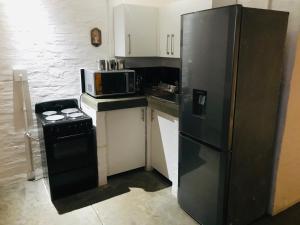 a kitchen with a black refrigerator and a stove at Maboneng Craftsmanship place in Johannesburg