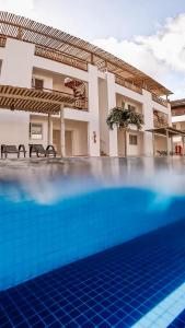 a swimming pool in front of a house at CANOA - Boas Vistas in Canoa Quebrada