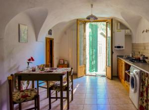 a kitchen and dining room with a table and chairs at sax & rosa in Pigna