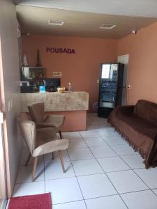 a room with a couch and a chair and a counter at Pousada Dom Kilmer in Fortaleza