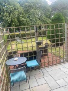 a patio with a table and chairs and a fence at Lovely 2 bedroom with private garden in Edinburgh