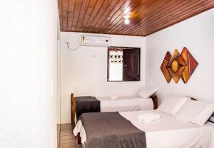 a room with two beds and a window at Pousada Bon Vivant in Porto De Galinhas