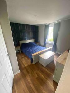 a bedroom with a blue bed and a window at Lovely 2 bedroom with private garden in Edinburgh