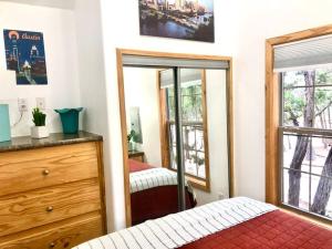 um quarto com uma cama, uma cómoda e um espelho em The Coyote Cabin - Cabins at Rim Rock em Austin