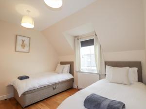 two beds in a room with a window at One Wester in Muir of Ord