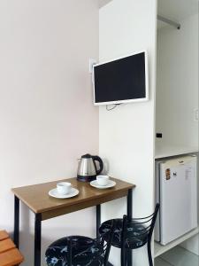 a small kitchen with a table and two chairs at Pousada Figueira in Guarda do Embaú