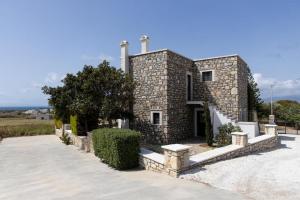 un edificio de piedra con una escalera delante en Villa Kaly, en Agia Anna de Naxos