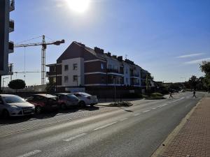 a street with cars parked next to a building at Apartament SIECHNICE in Siechnice