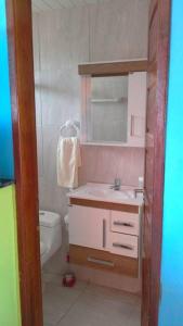 a bathroom with a sink and a toilet and a mirror at Swiss Flats in Porto De Galinhas