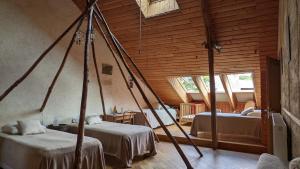 Habitación con 2 camas en una habitación con paredes de madera. en L'Hôt'Berge, en La Chapelle-de-Brain