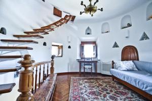 a living room with stairs and a blue couch at Castle Panigirakis in Mikonos