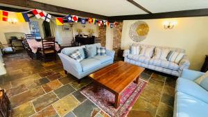 - un salon avec des canapés et une table en bois dans l'établissement Donore - Quintessential English Cottage close to Dittisham Quay, à Dittisham
